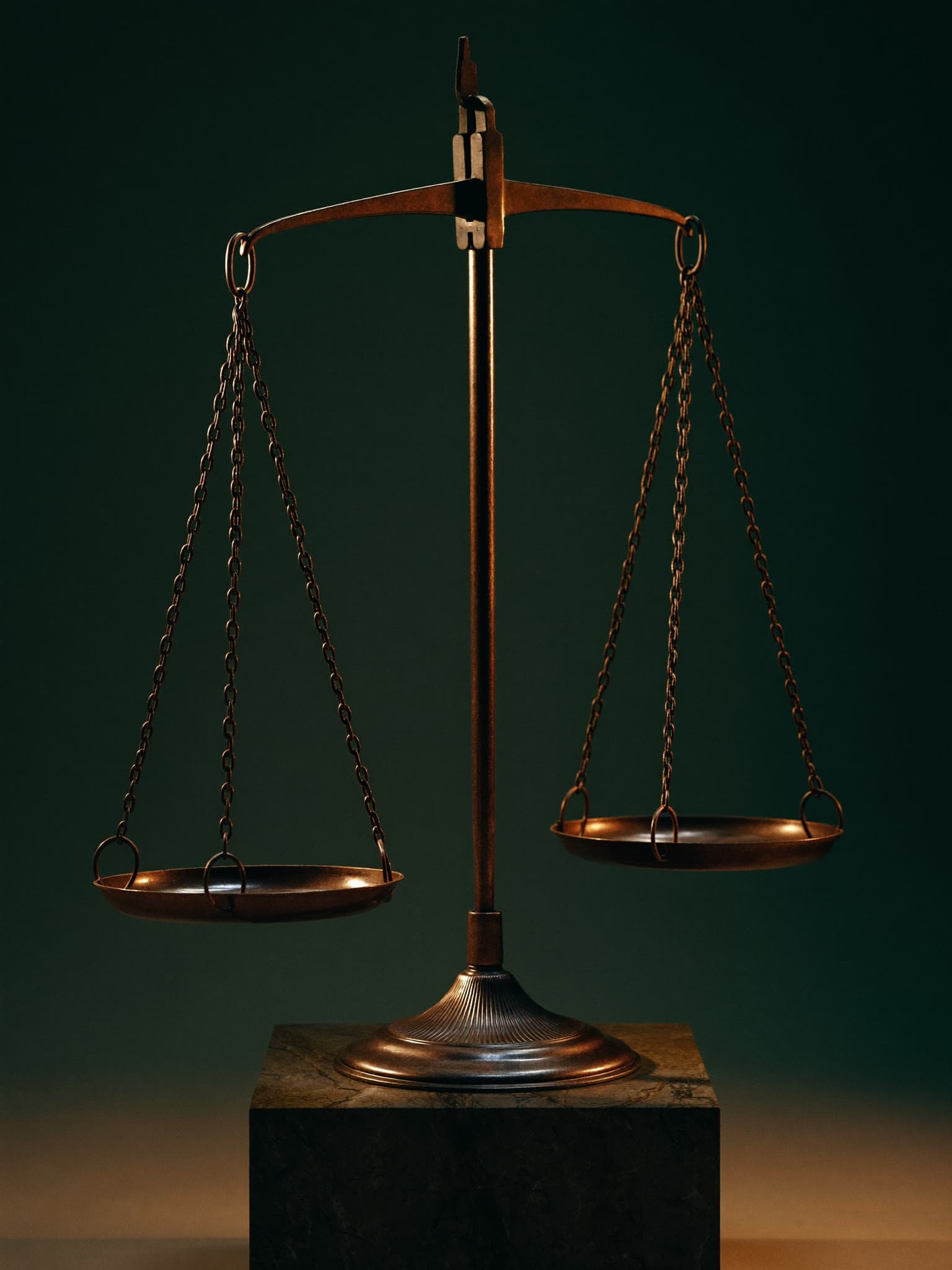 Balanza de bronce en equilibrio perfecto sobre un pedestal de piedra.
